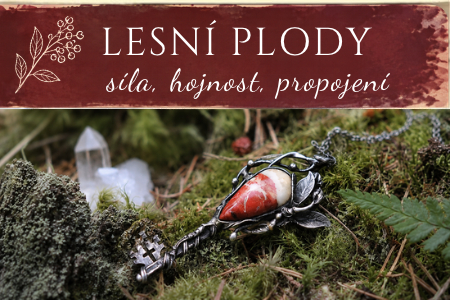 Cínovaný náhrdelník s červeným kamenem leží v mechu a lesních plodech, v pozadí kouř.